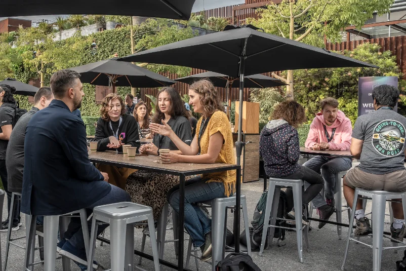 Attendees talking at outdoor tables